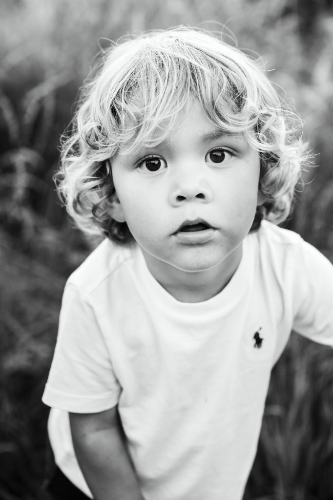 Zwart-wit kinderportret van een jongen met grote ogen tijdens een gezinsfotoshoot