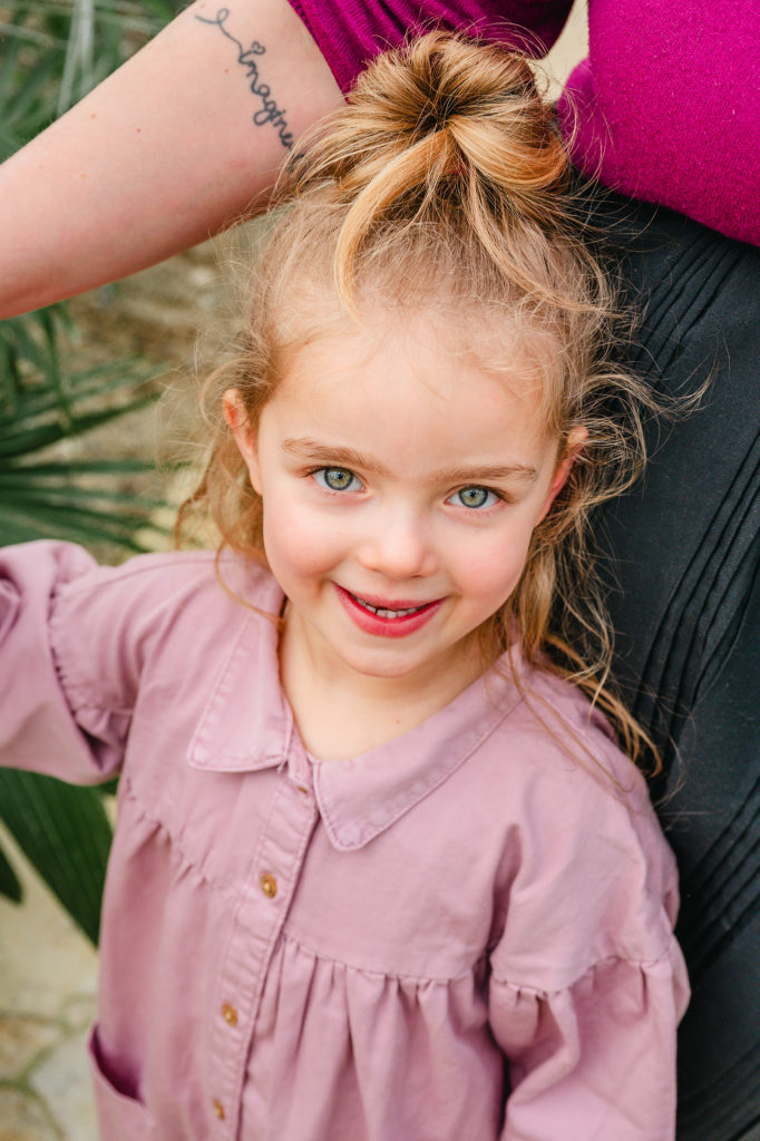 Kinderportret van meisje in de armen van haar mama in de plantentuin van Meise