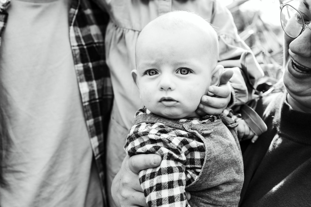 Zwart/wit foto van jongen omringd door zijn gezin in de plantentuin van Meise